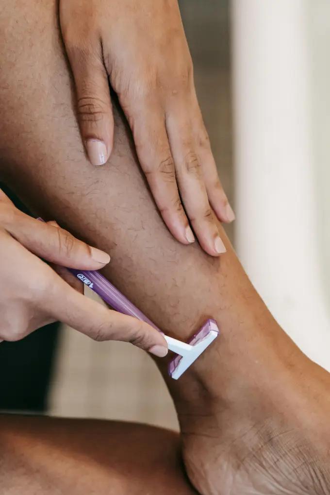 Shaving cream applied to a leg before shaving with a disposable razor