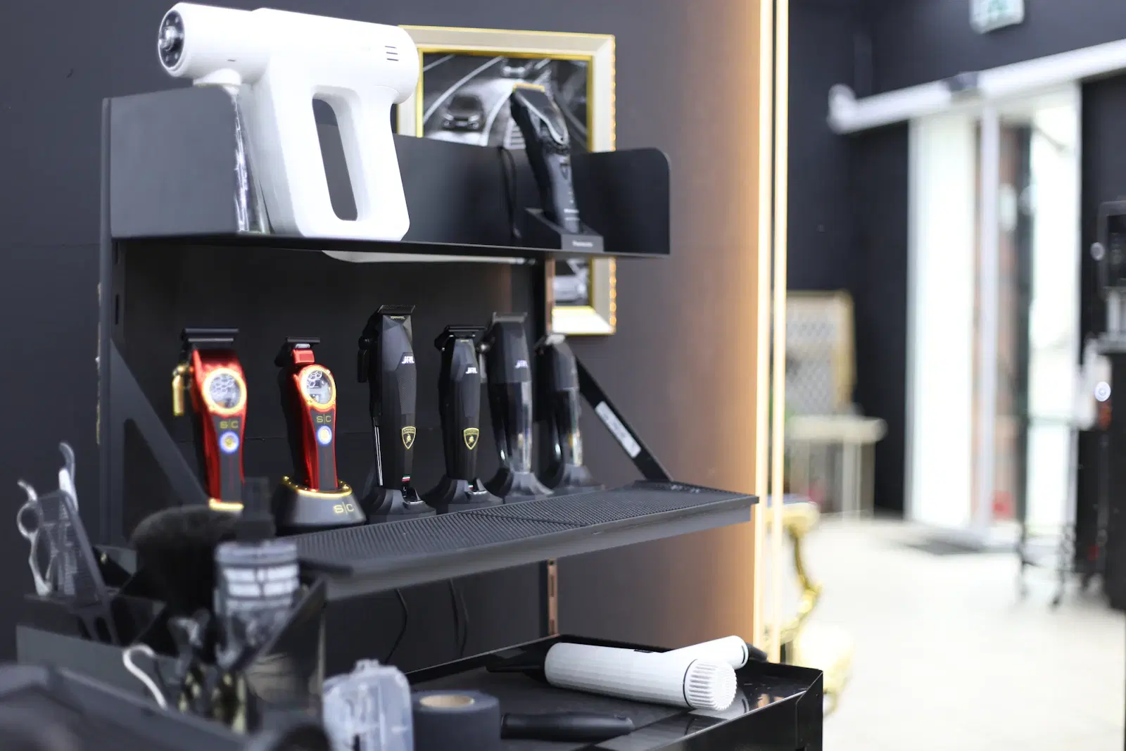Electric trimmers and clippers lined up on a barbershop shelf