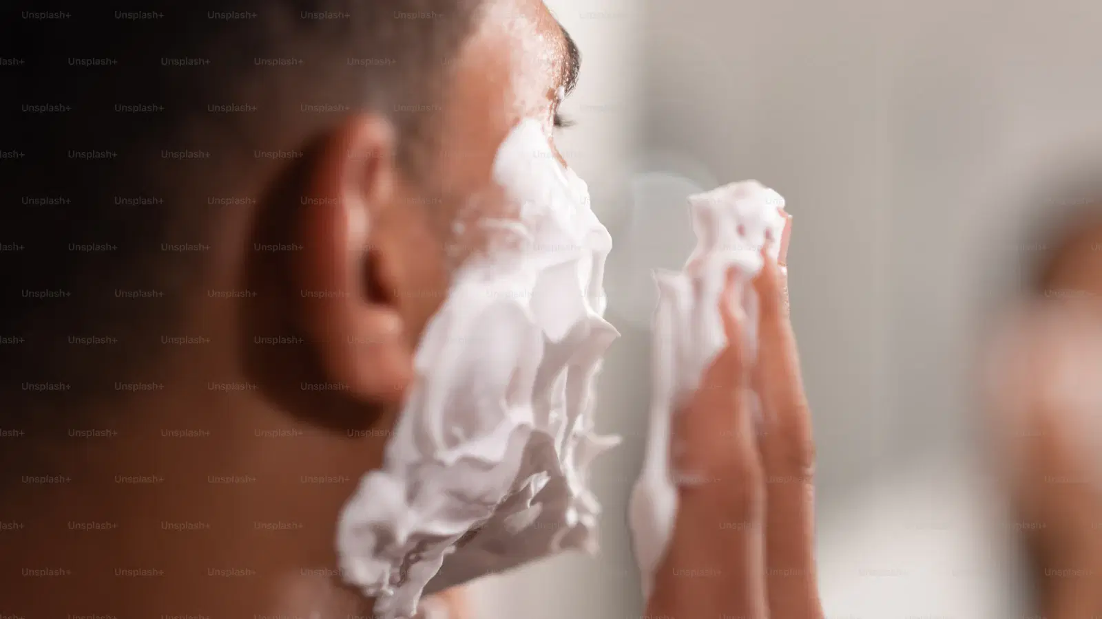 Panasonic four-blade electric cordless trimmer being used for pubic grooming — wide head, multiple blades, reduced passes over sensitive groin skin