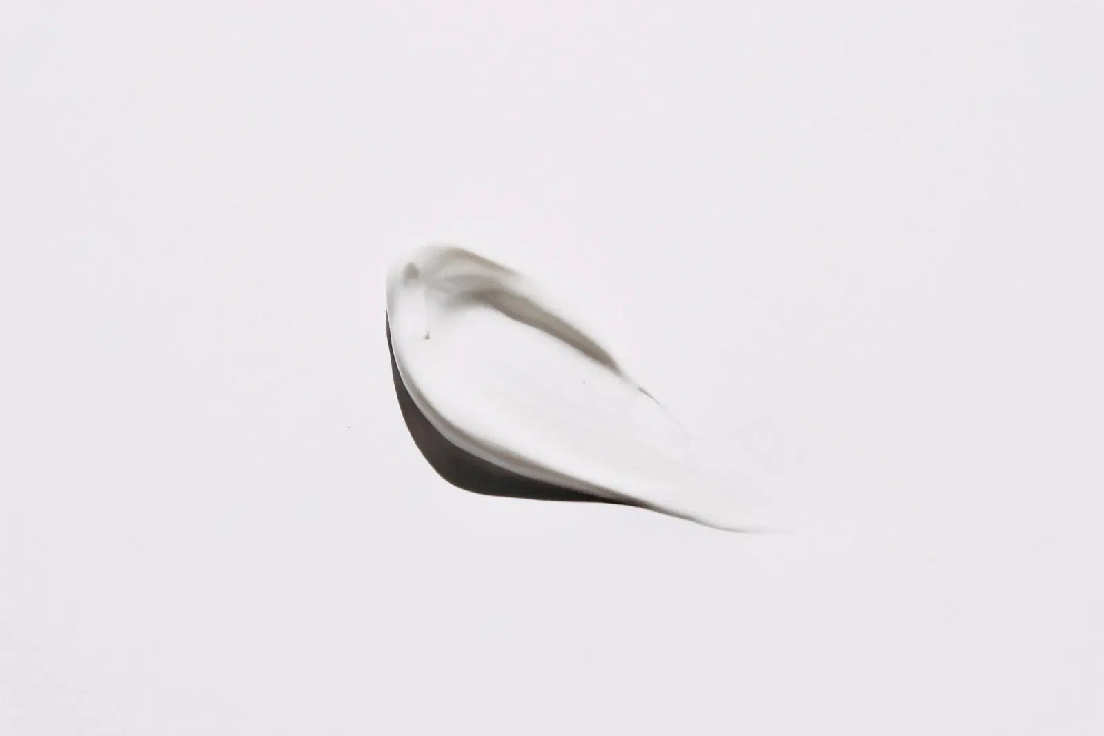 A swatch of white cream on a light gray background