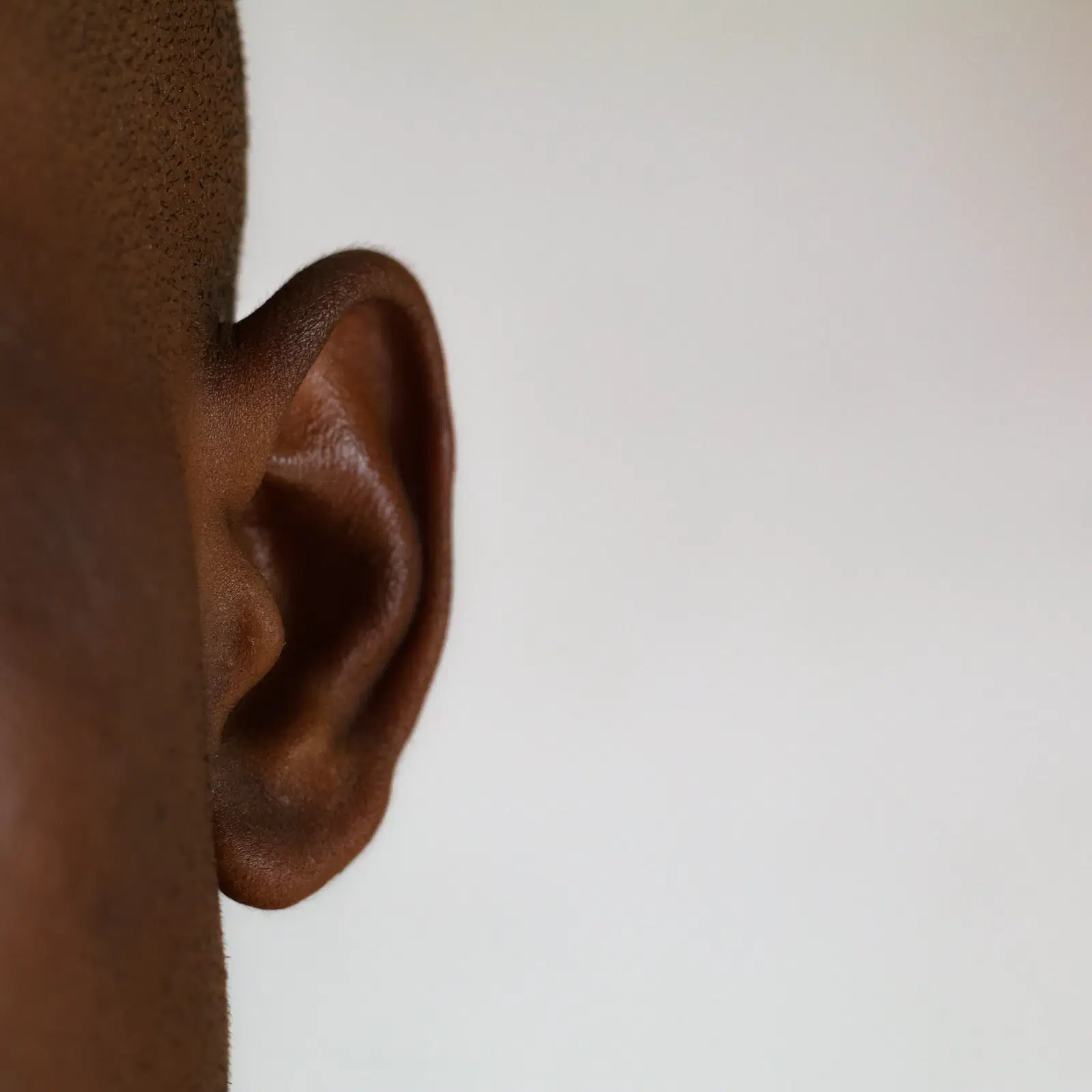 Side view of a man's ear against a white background