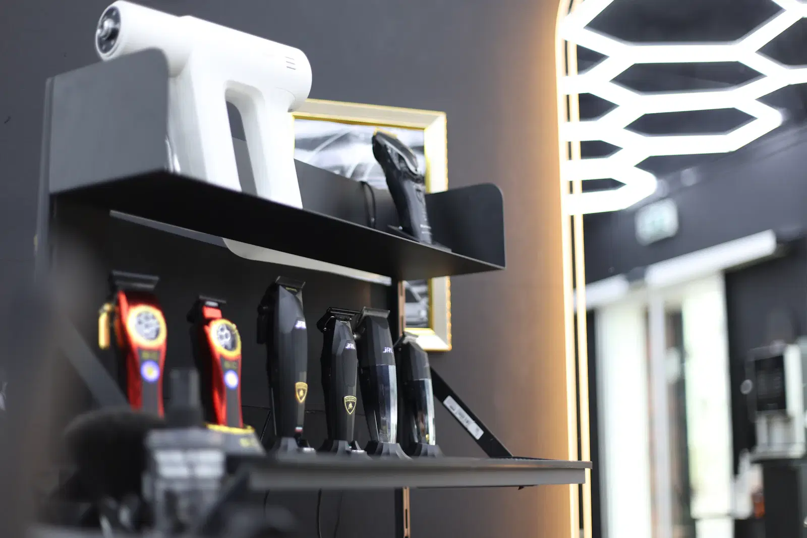 Electric trimmers and clippers lined up on a grooming shelf