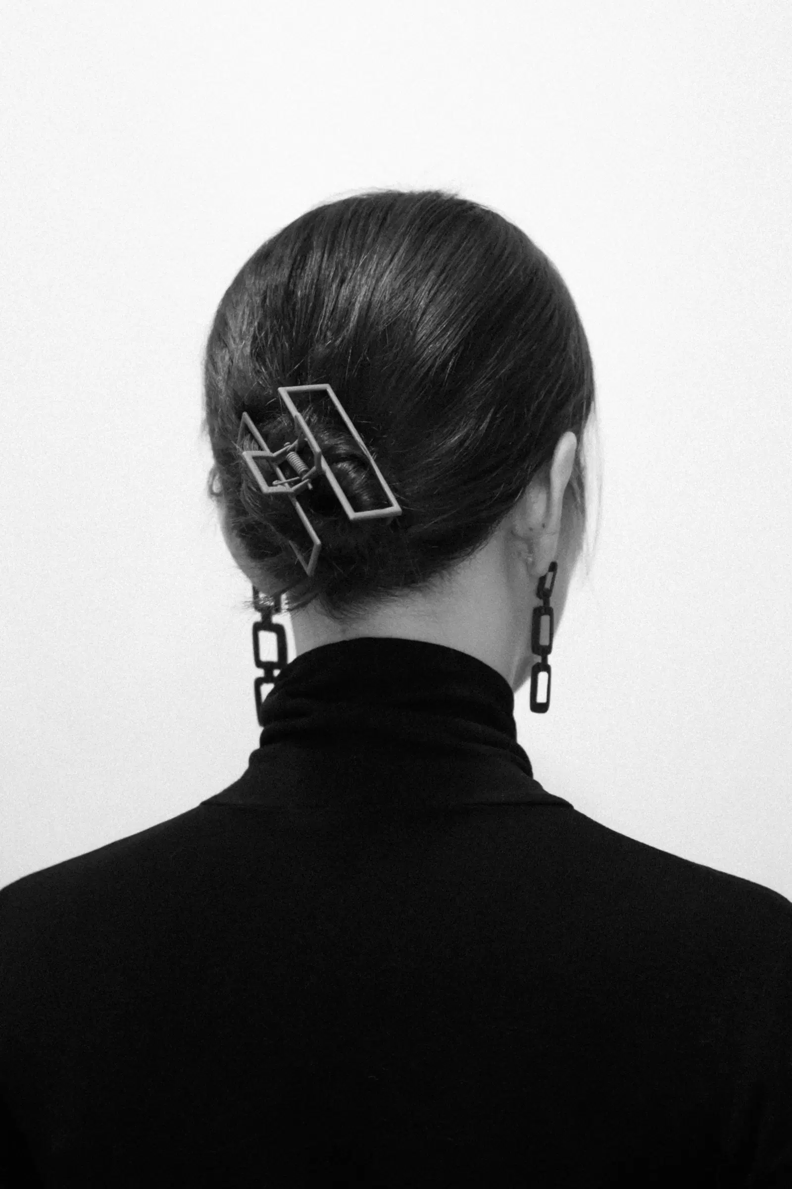 Black-and-white photo of a rectangular claw clip holding hair in a low bun
