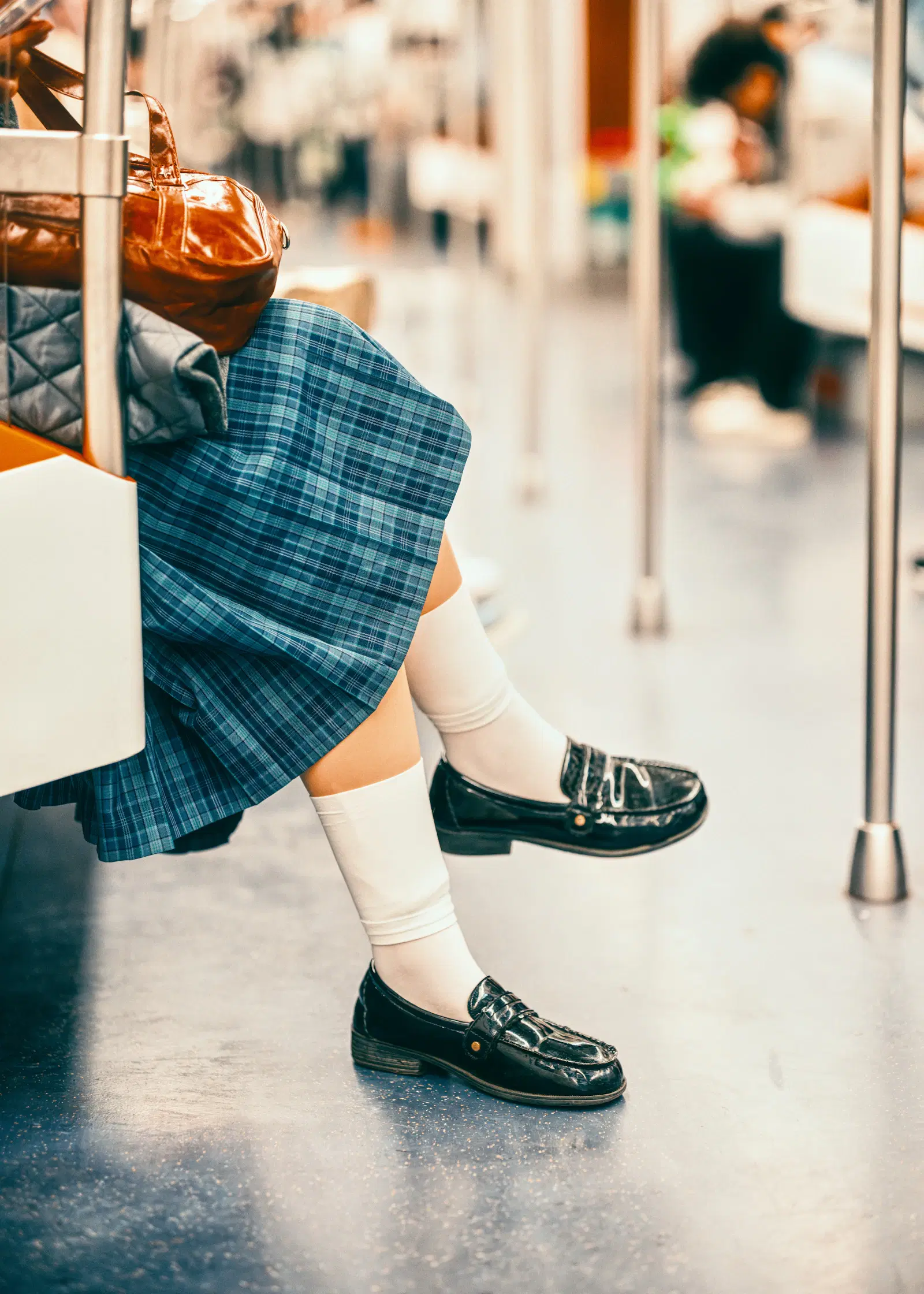 Blue plaid pleated skirt worn with white socks and black loafers