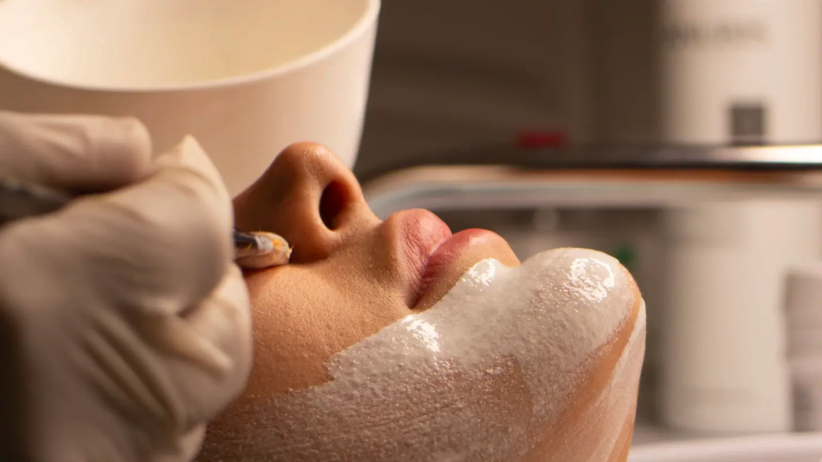 A ruler held next to pubic-area hair at the minimum 1/4 inch length needed for a successful wax — the exact pubic hair length chart for waxing