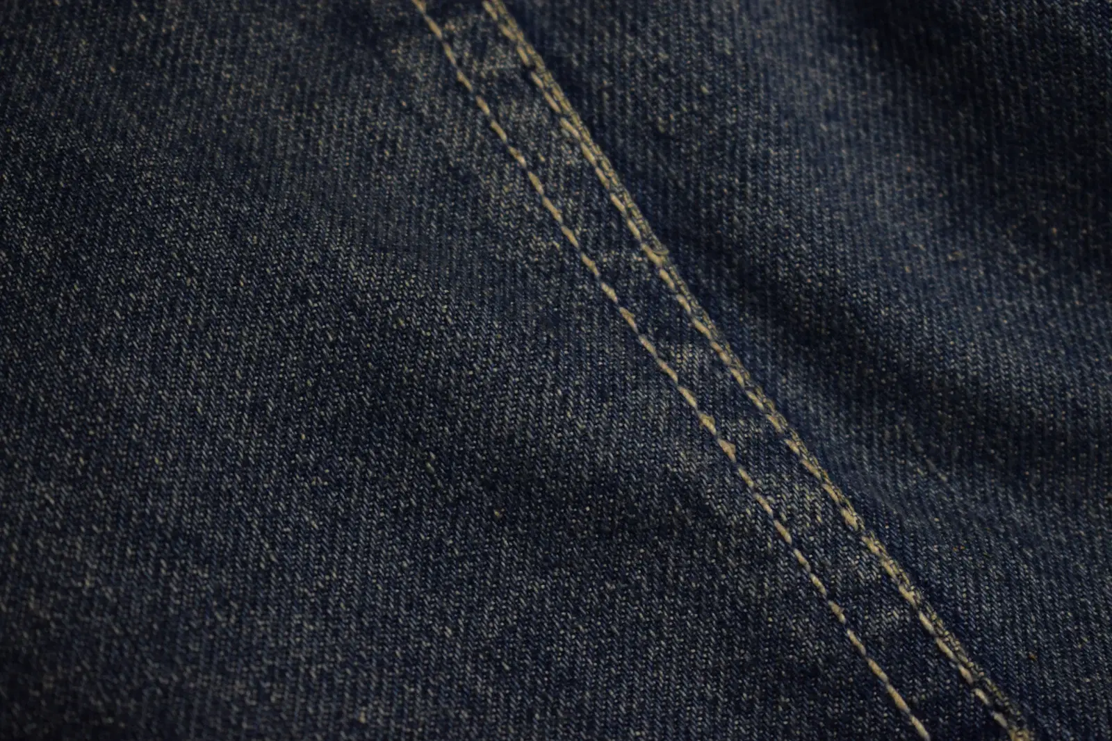Close-up of a thick denim seam, the kind that rubs inner-thigh skin in tight jeans
