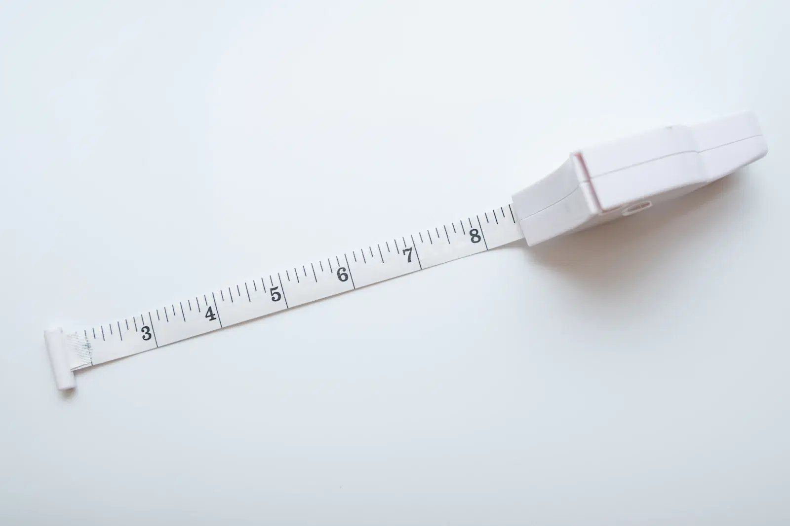 A white retractable body tape measure on a white background