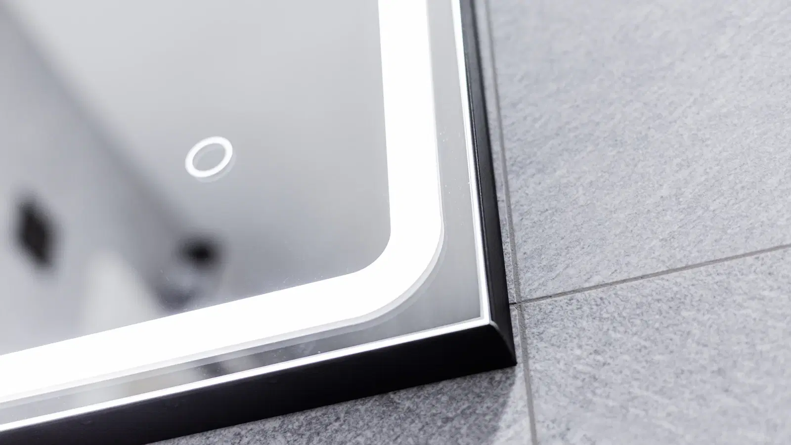 Slant-tip tweezers laid next to a small mirror on a clean white surface — the tools used for tweezing stray pubic hair safely