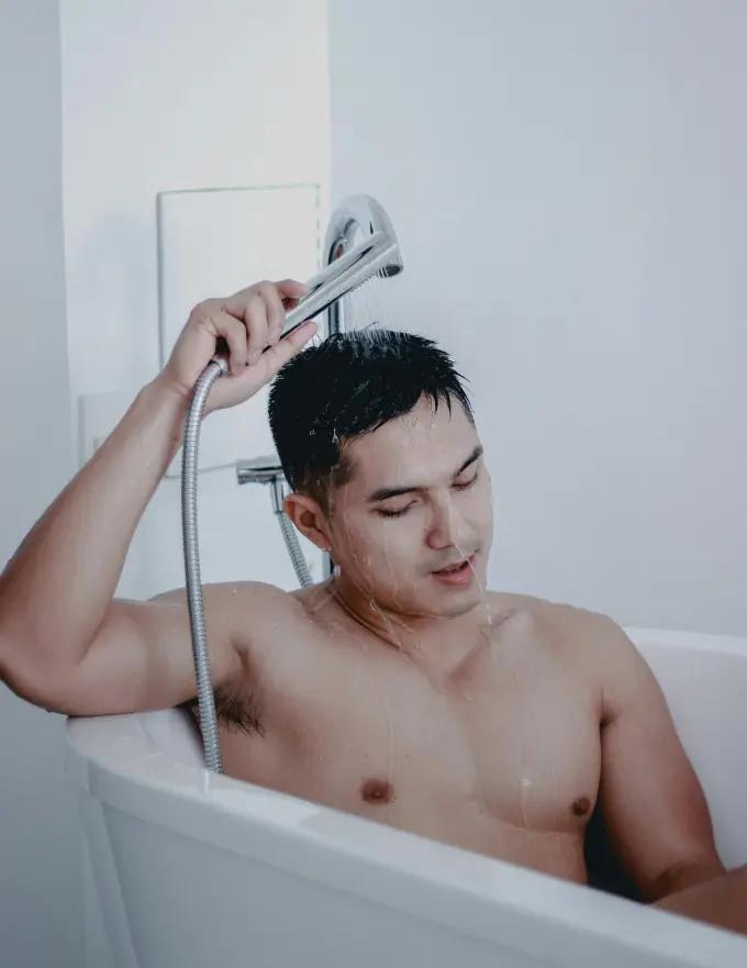 A person showering with softened, conditioned body hair