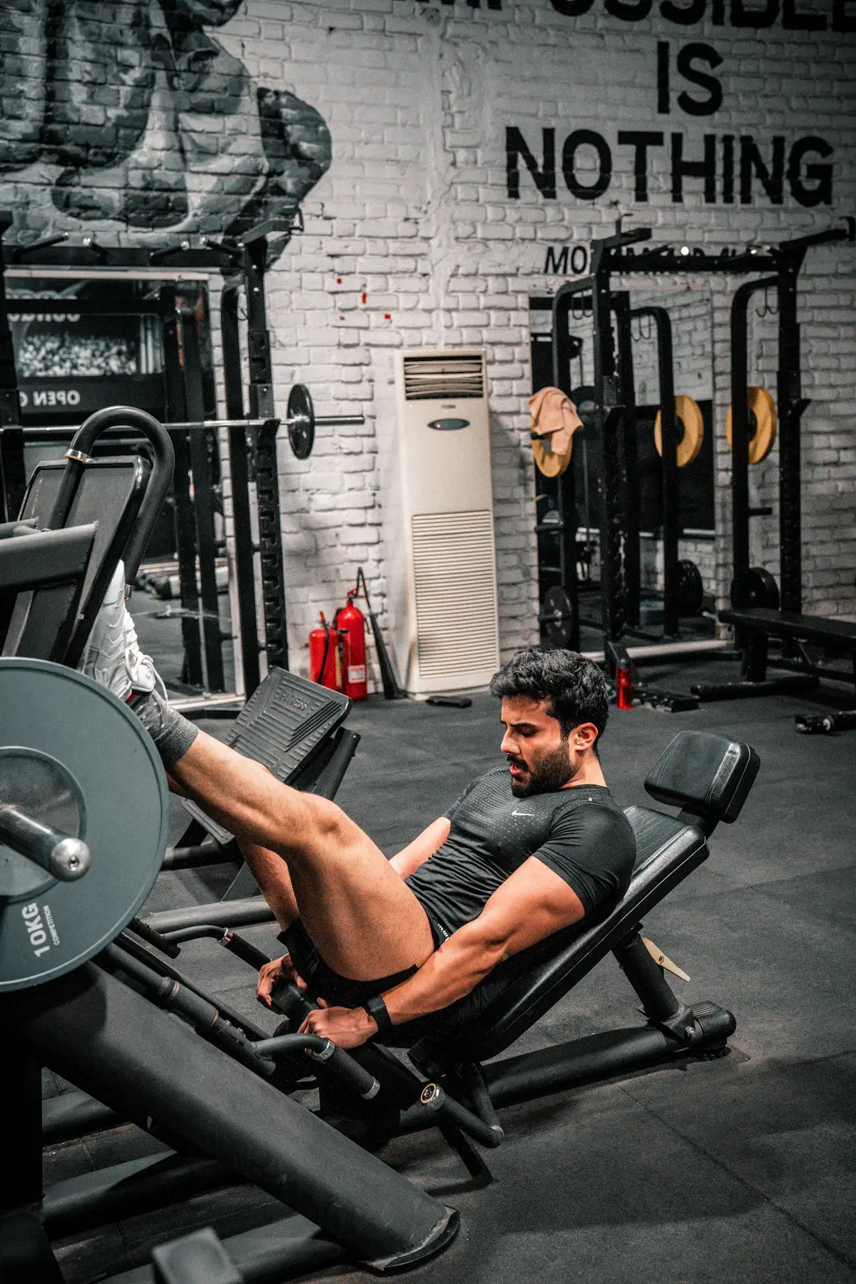 Man training on a leg press machine in a gym to build fuller femboy thighs
