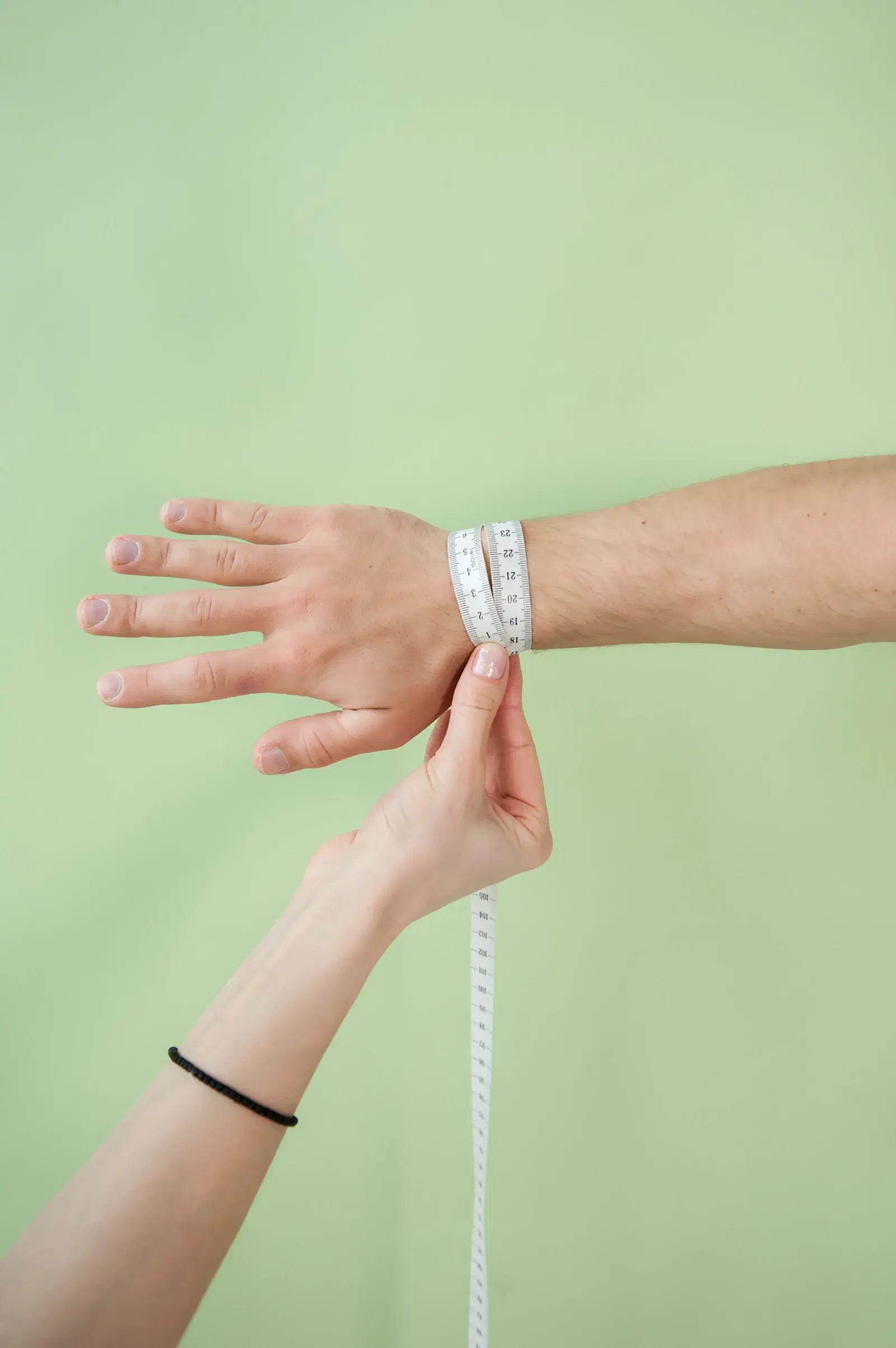 Soft tape measure wrapped around a wrist, the same flexible tape you use to measure thigh circumference