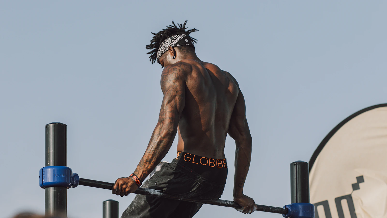 Animated demo of a standing banded kickback — slight forward lean, kick one leg back to full extension, squeeze the glute at the top